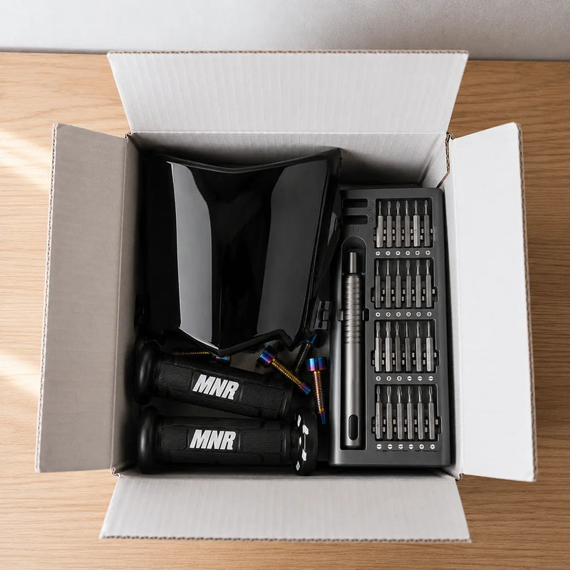 MotoBox monthly mystery box open showing Zorix R8 ebike parts, grips, and tools.
